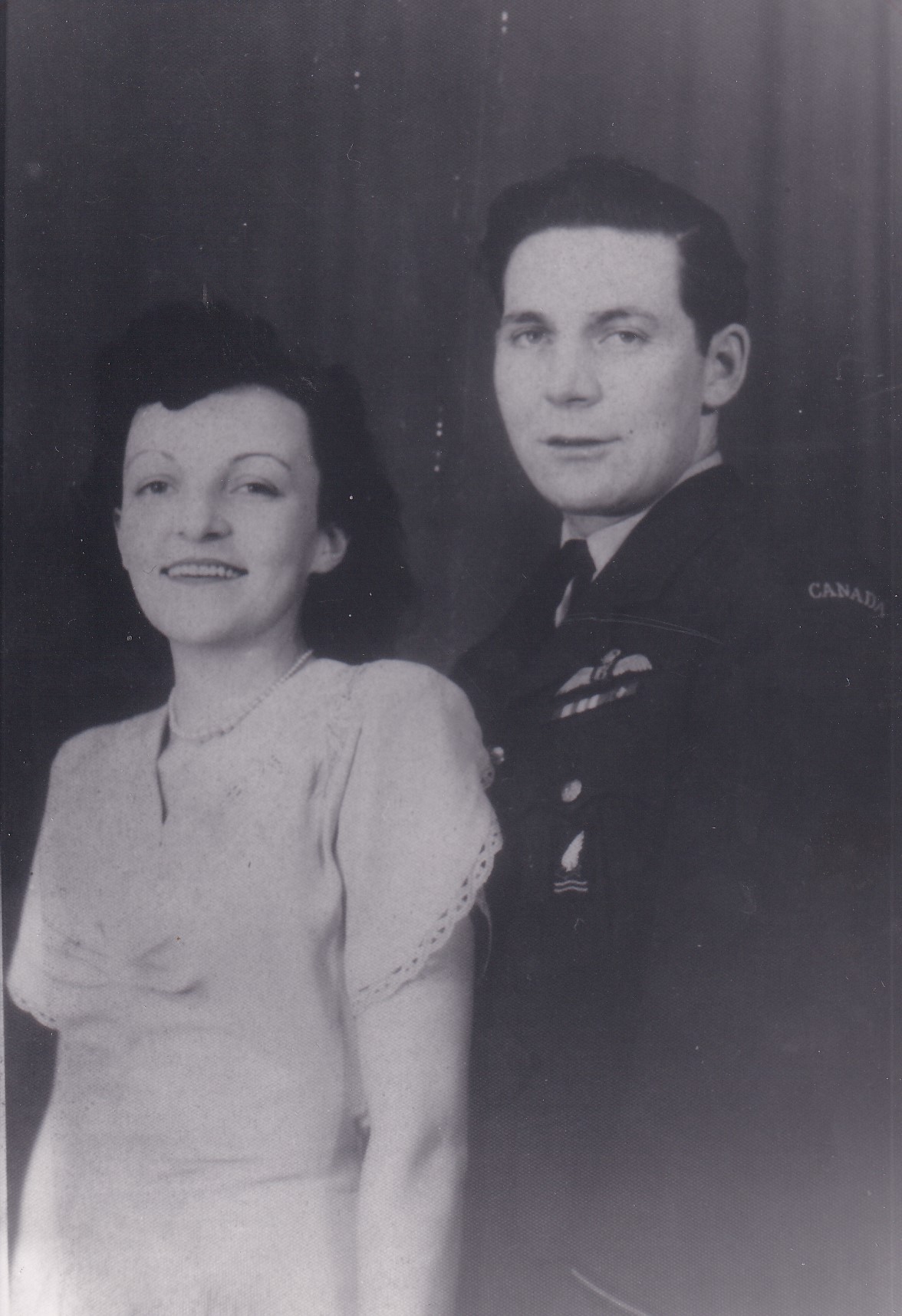 Portrait of Doreen Healy Davis seated beside Charles Gordon Goodwin Pat Davis in Royal Canadian Air Force uniform.